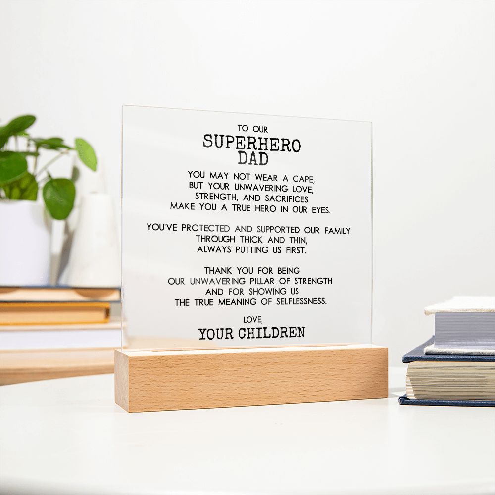 On The Desk Farther View Of Square Acrylic Plaque With Wooden Base With Message For Superhero Dad - Elegant Endearments